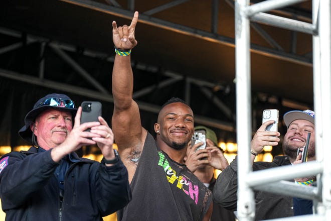 Bijan Robinson, running back for the Atlanta Falcons and former Texas Longhorn, holds up the sign of the horns for the crowd ahead of a performance by Ludacris on the Pony Up stage at the Two Step Inn country music festival at San Gabriel Park on Sunday, April 21, 2024 in Georgetown, Texas.